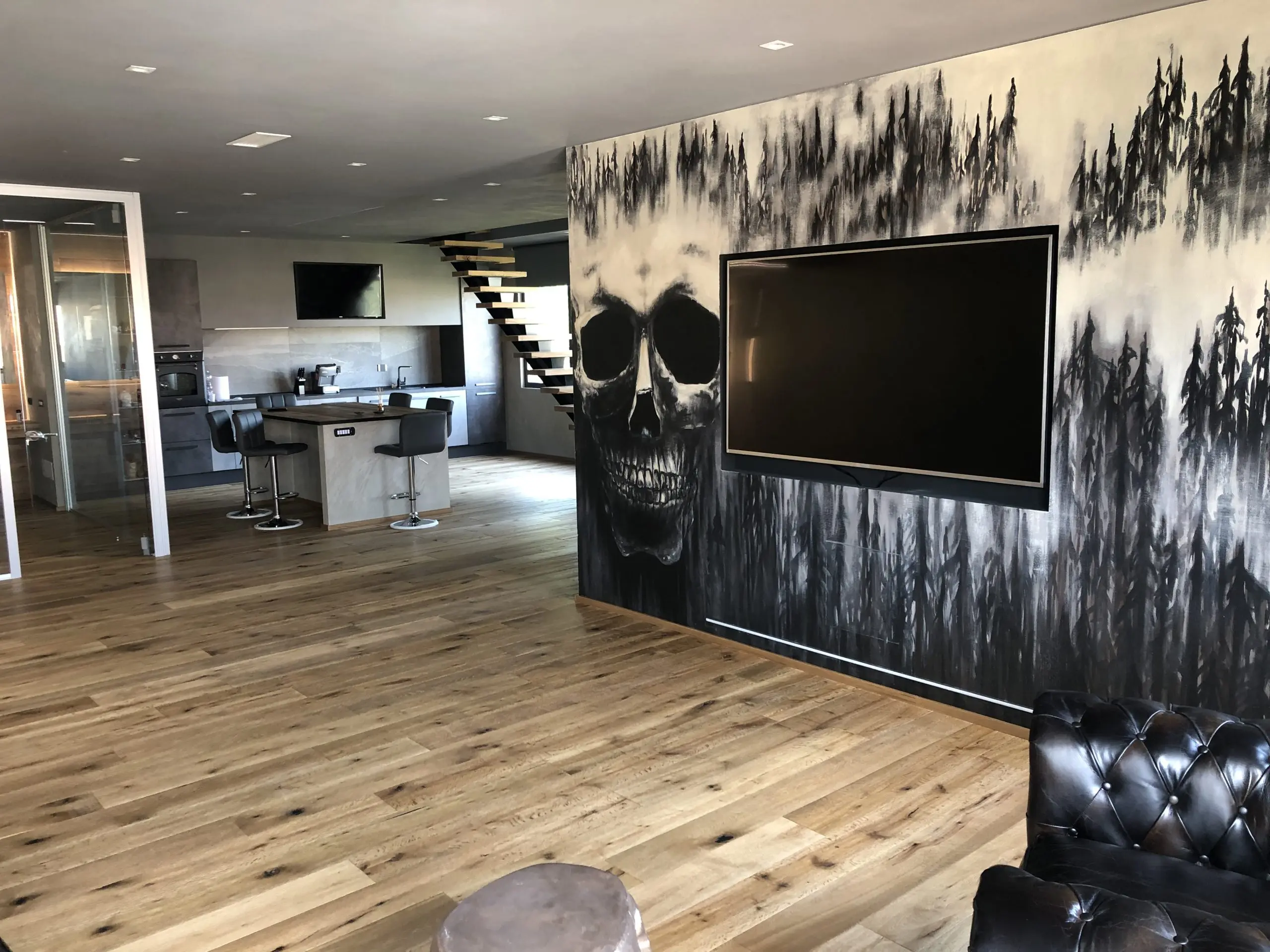 Ambiente ultimato con parete decorativa, pavimento in legno e arredi