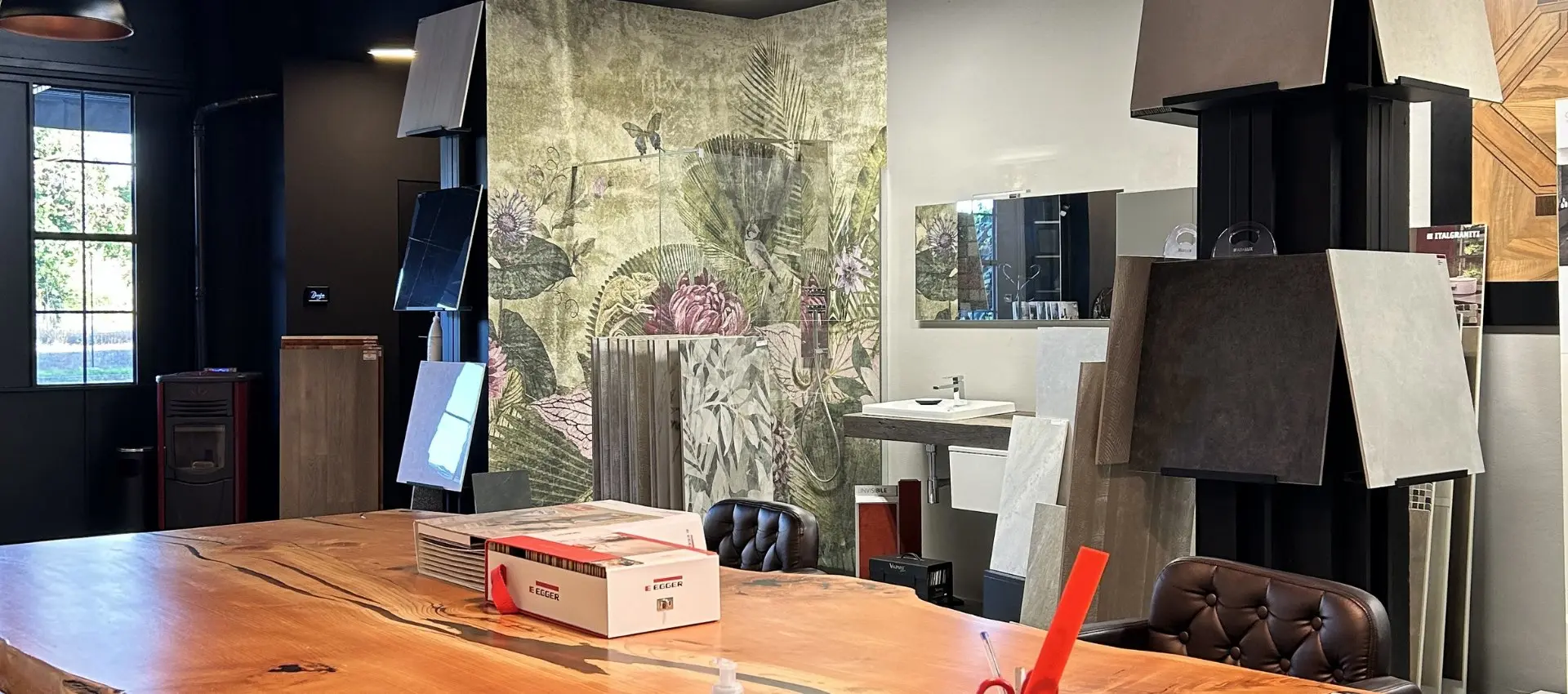 Spazio showroom Decofin con tavolo, materiali e parete decorativa